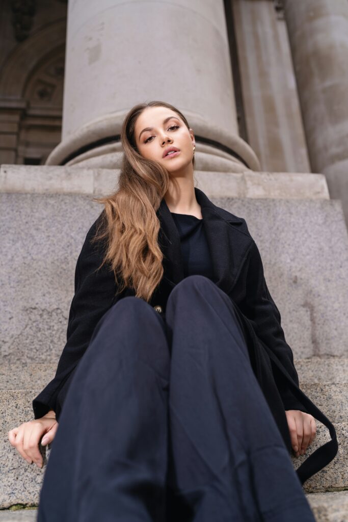 A close-up of a model gently touching her cheek, with visible dryness and flaking—illustrating the real texture of dry skin.